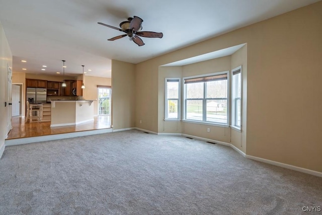 unfurnished living room with recessed lighting, light colored carpet, baseboards, and ceiling fan