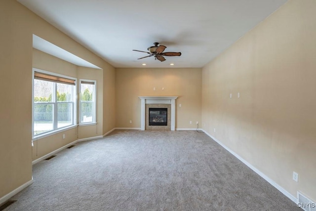 unfurnished living room with visible vents, baseboards, recessed lighting, a tile fireplace, and carpet flooring