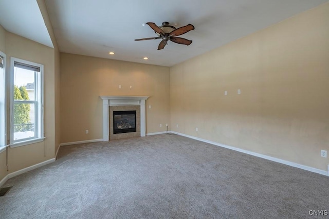 unfurnished living room featuring a tiled fireplace, recessed lighting, carpet flooring, baseboards, and ceiling fan