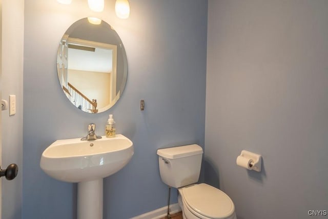 bathroom with baseboards and toilet