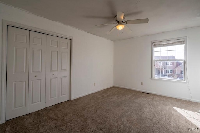 unfurnished bedroom with visible vents, a closet, carpet flooring, baseboards, and ceiling fan