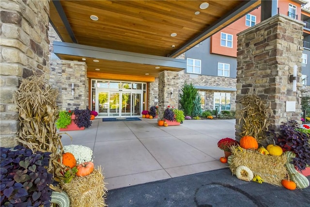 entrance to property featuring stone siding and french doors