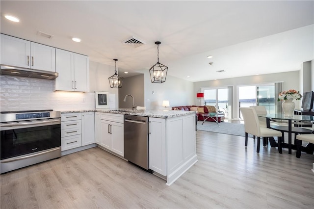 kitchen with visible vents, a sink, white cabinets, under cabinet range hood, and appliances with stainless steel finishes