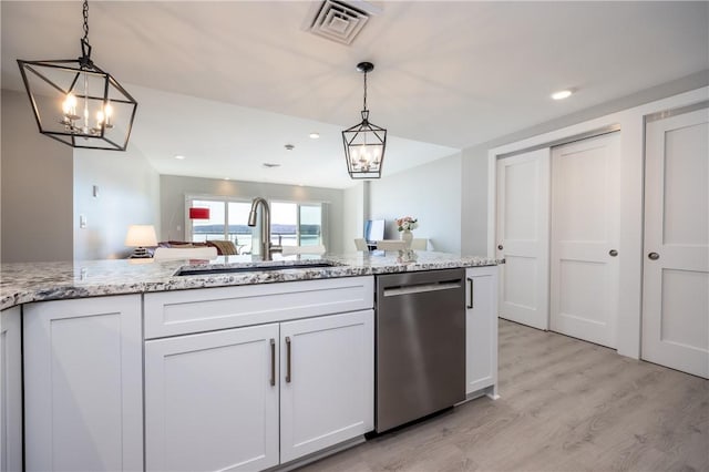 kitchen featuring visible vents, light wood-style flooring, a sink, light stone countertops, and dishwasher