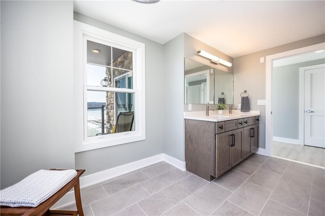 full bath with vanity, baseboards, and tile patterned flooring