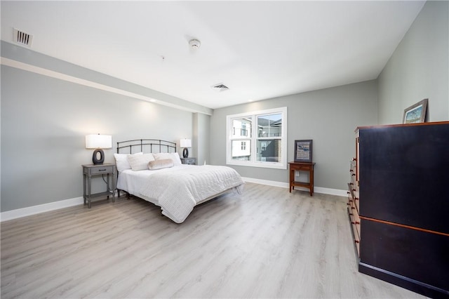 bedroom featuring visible vents, baseboards, and light wood-style floors