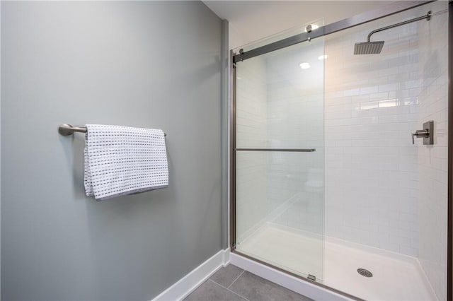 full bathroom with tile patterned floors, baseboards, and a stall shower