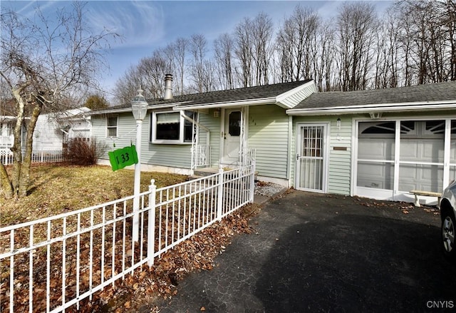 single story home with driveway, an attached garage, and fence