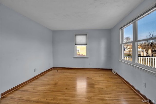 spare room with visible vents, baseboards, and light wood-style flooring