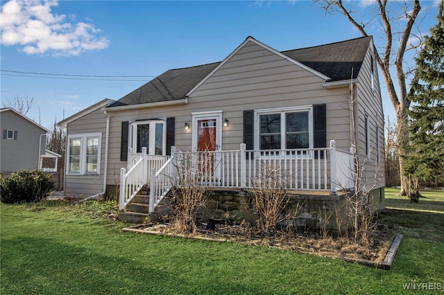 bungalow-style house with a front yard, a porch, and roof with shingles