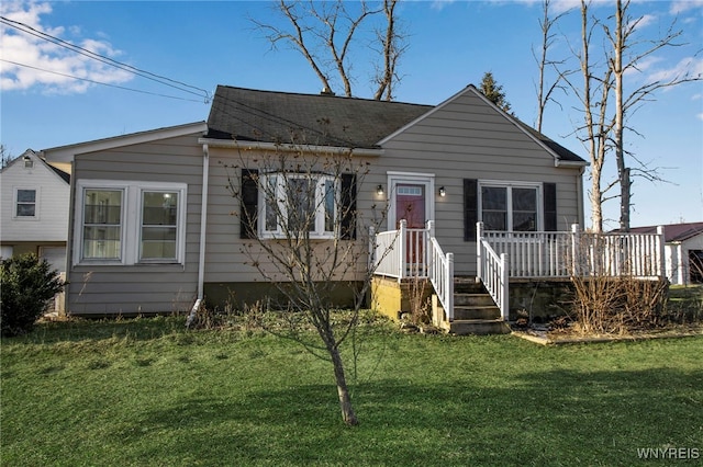 bungalow-style home featuring a deck, a front yard, and a shingled roof