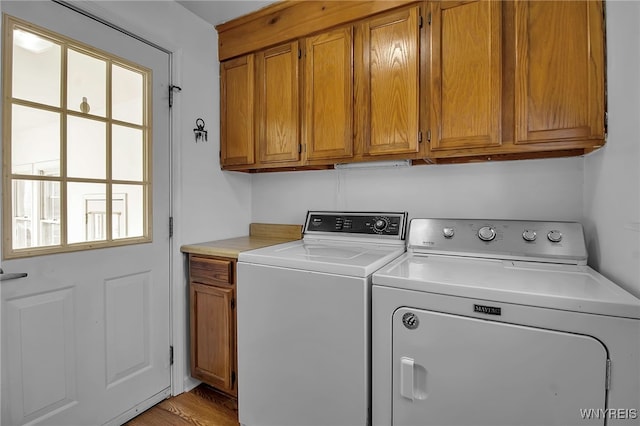 clothes washing area with cabinet space and separate washer and dryer