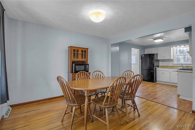 dining room with visible vents, a textured ceiling, baseboards, and light wood-style floors