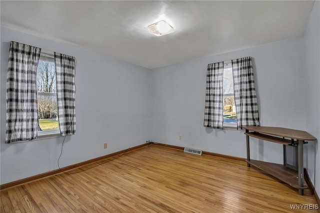 unfurnished room featuring visible vents, baseboards, and light wood-style floors