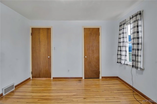 unfurnished bedroom with visible vents, baseboards, and light wood finished floors