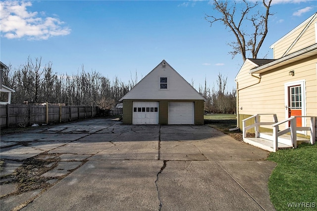 detached garage featuring fence