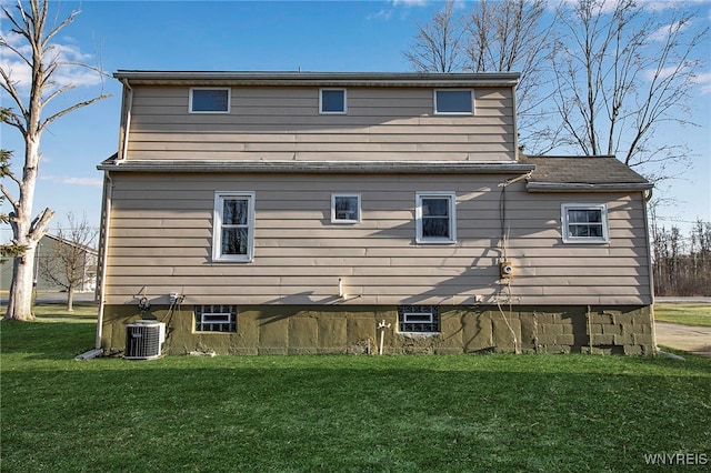 rear view of property featuring central AC and a yard