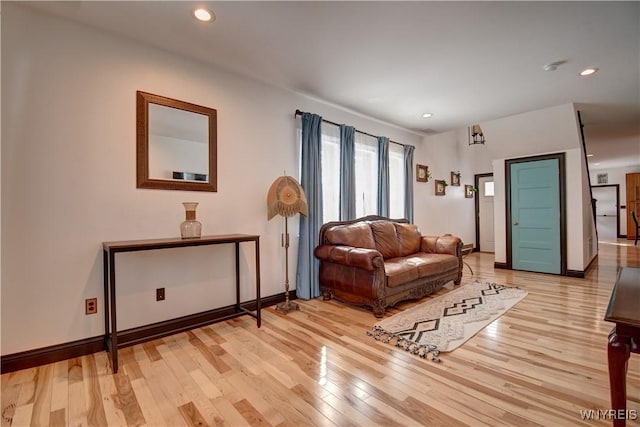 living room featuring recessed lighting, baseboards, and light wood-style floors