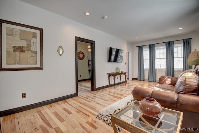 living room with light wood-style flooring, recessed lighting, and baseboards