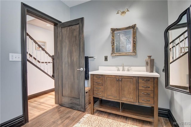 bathroom featuring baseboards, wood finished floors, and vanity