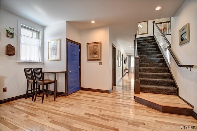 entryway with recessed lighting, baseboards, light wood-style flooring, and stairs