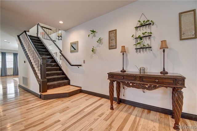 stairway featuring visible vents, recessed lighting, baseboards, and wood finished floors