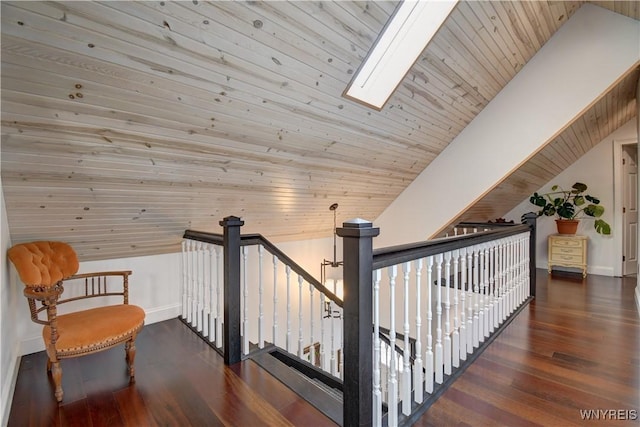 interior space featuring baseboards, lofted ceiling with skylight, wood ceiling, and wood finished floors