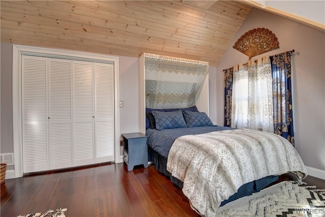 bedroom featuring visible vents, wood finished floors, a closet, baseboards, and vaulted ceiling