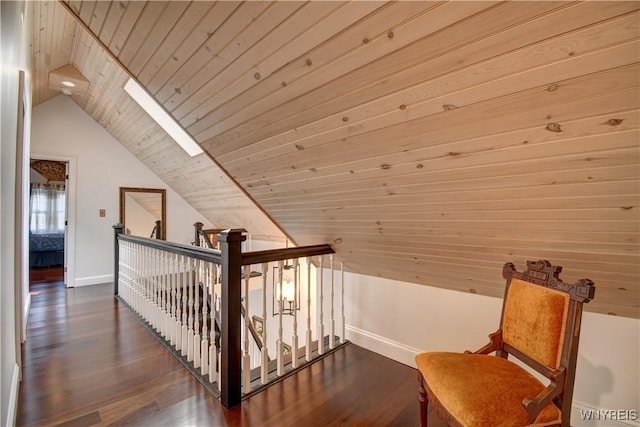 additional living space with baseboards, vaulted ceiling with skylight, wood ceiling, and dark wood-style flooring