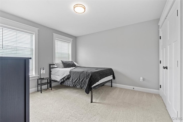 bedroom featuring carpet flooring, baseboards, and a closet