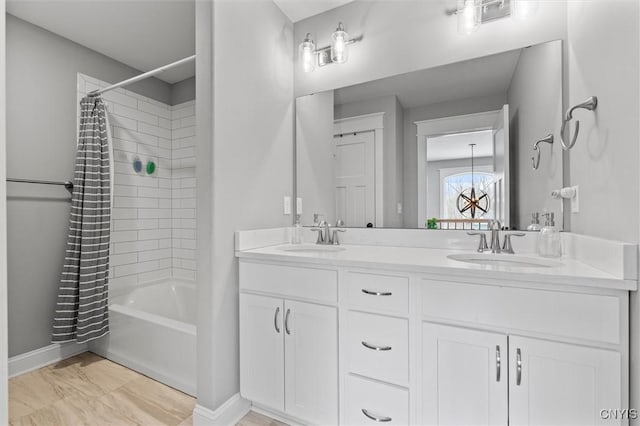 bathroom with a sink, baseboards, shower / tub combo with curtain, and double vanity