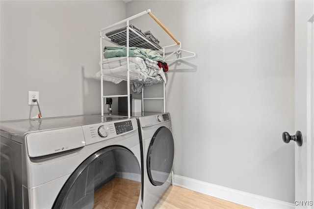 laundry room featuring laundry area, independent washer and dryer, baseboards, and wood finished floors