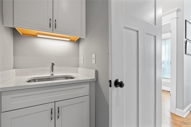 bathroom featuring baseboards, wood finished floors, and vanity