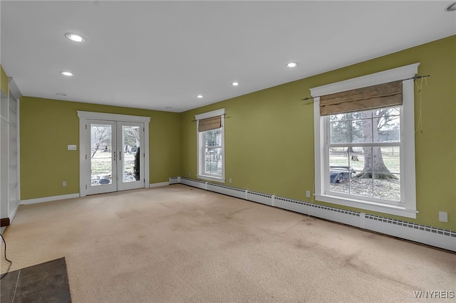 unfurnished room with light carpet, recessed lighting, french doors, and a baseboard heating unit