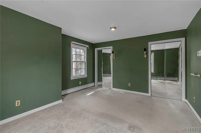 unfurnished bedroom with carpet, baseboards, a baseboard radiator, a closet, and a baseboard heating unit