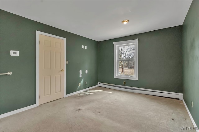 spare room with a baseboard radiator, baseboards, and carpet