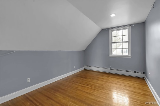 bonus room with lofted ceiling, wood finished floors, baseboards, and baseboard heating