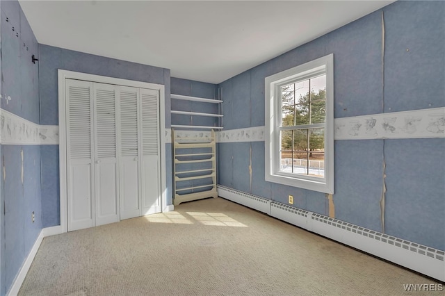 interior space with a baseboard radiator, carpet floors, and a closet