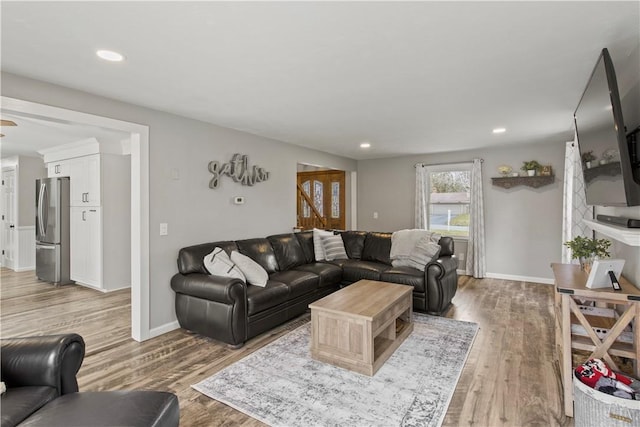 living area featuring recessed lighting, baseboards, and light wood-style flooring