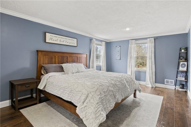 bedroom with visible vents, baseboards, ornamental molding, dark wood-style floors, and a textured ceiling