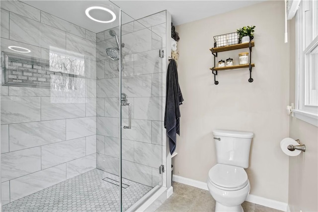 full bathroom with tile patterned flooring, a stall shower, toilet, and baseboards