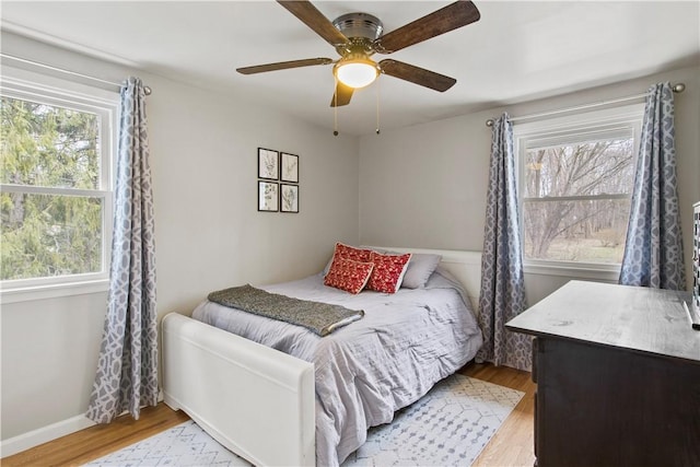 bedroom with wood finished floors, baseboards, and ceiling fan