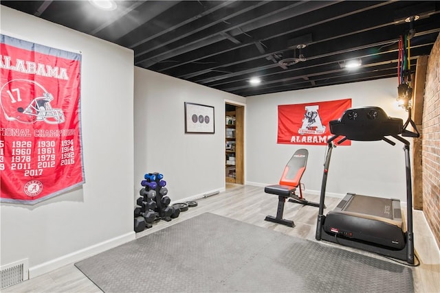 workout room featuring visible vents, baseboards, and wood finished floors