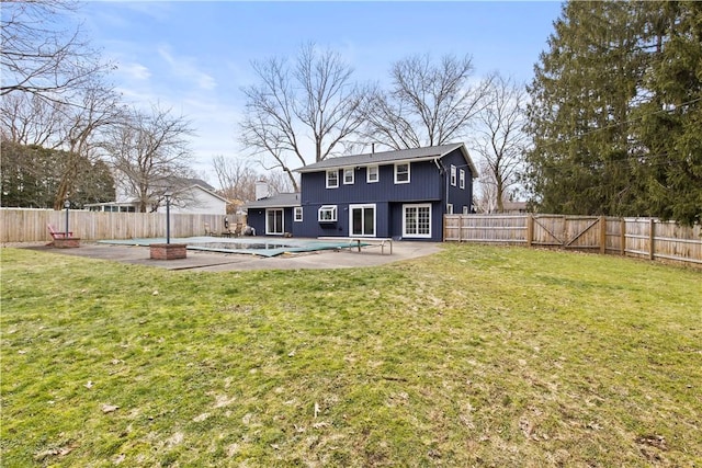 back of property featuring a fenced backyard, a yard, and a patio