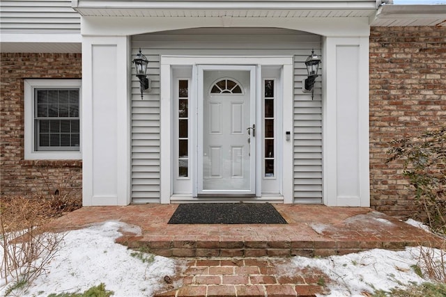 doorway to property featuring brick siding