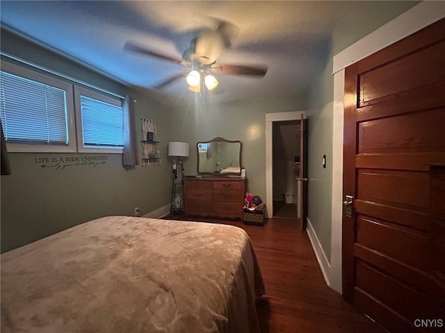 bedroom featuring baseboards, wood finished floors, and a ceiling fan