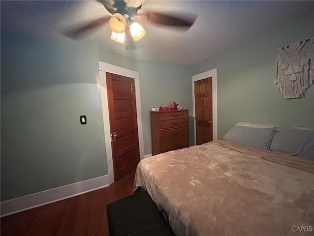 bedroom with a ceiling fan, baseboards, and wood finished floors