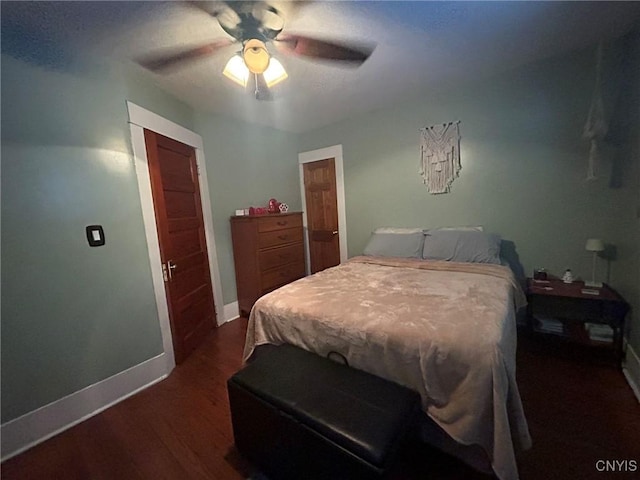 bedroom with baseboards, dark wood finished floors, and a ceiling fan