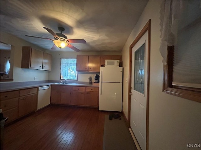 kitchen with light countertops, dark wood-style floors, white appliances, a ceiling fan, and a sink