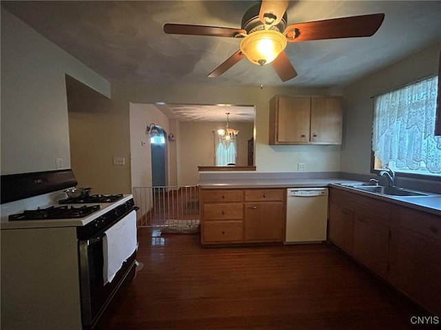 kitchen with dark wood-type flooring, light countertops, a peninsula, white appliances, and a sink